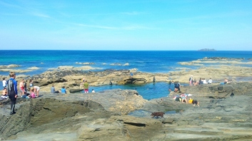 People swimming in a rockpool in Cornwall